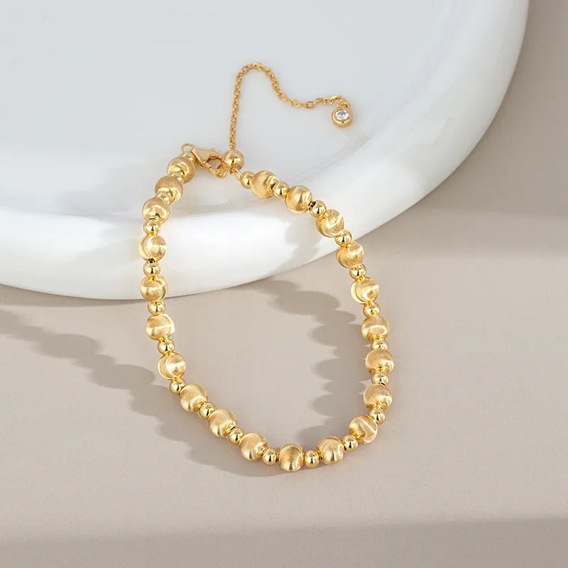 Gold-color round bead bracelet with brushed beads and extender chain