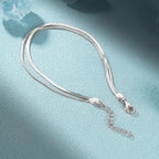 Silver double snake chain bracelet showing one wider chain, one finer chain, a lobster clasp and an extender chain