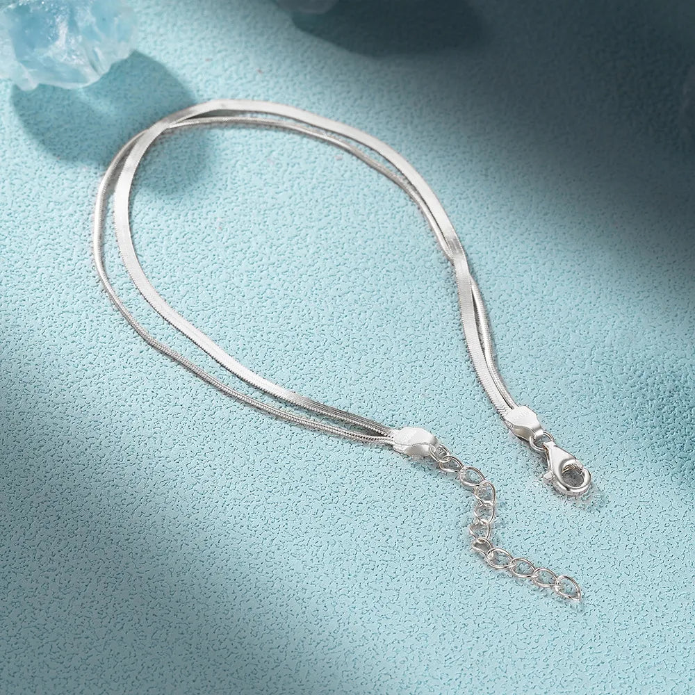 Silver double snake chain bracelet showing one wider chain, one finer chain, a lobster clasp and an extender chain