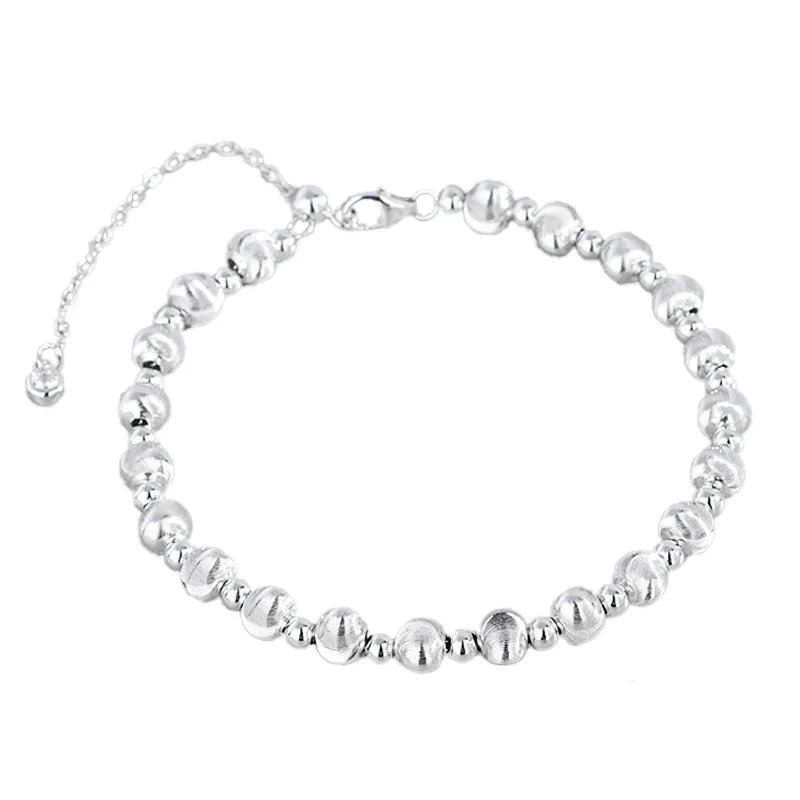 Silver round bead bracelet with alternating brushed beads and polished spacers on a white background