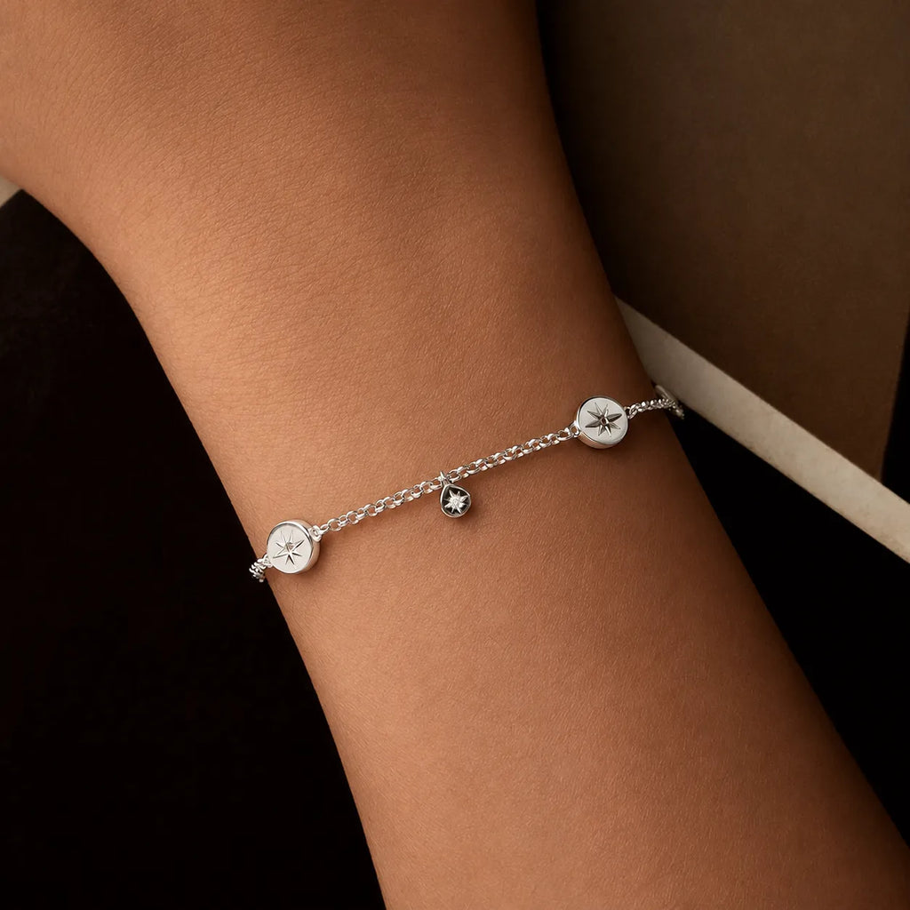 Silver sun bracelet with two round medallions and a small hanging motif worn on the wrist
