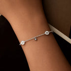 Silver sun bracelet with two round medallions and a small hanging motif worn on the wrist